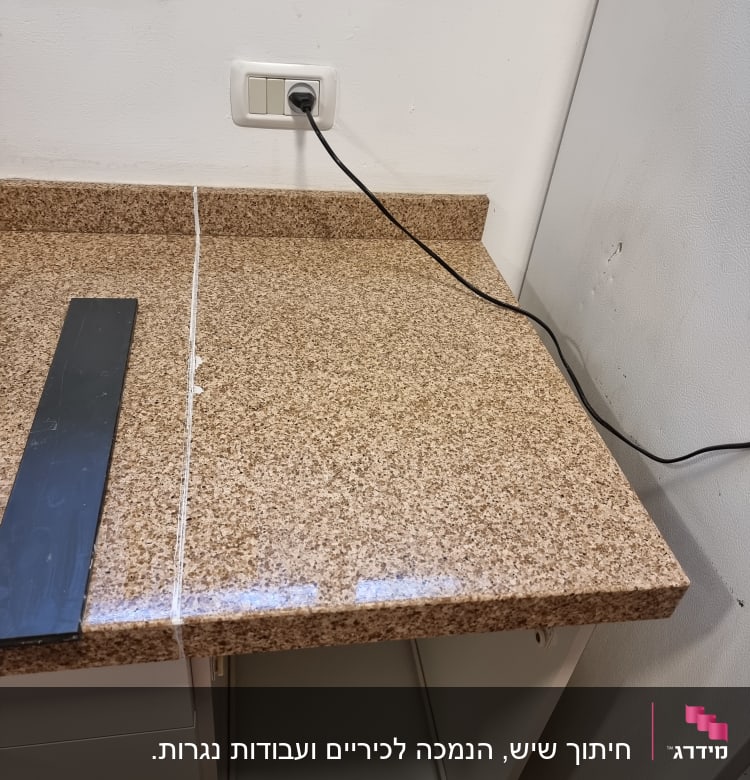 משטח שיש חום עם חיבור חשמלי על הקיר